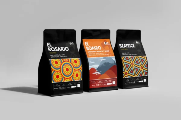 Three Mr. Tinto coffee bags: El Rosario (dark chocolate, nutty), El Bombo (sweet notes, fruity), and Beatrice (orange, nutty), Colombian single-origin coffee blends.